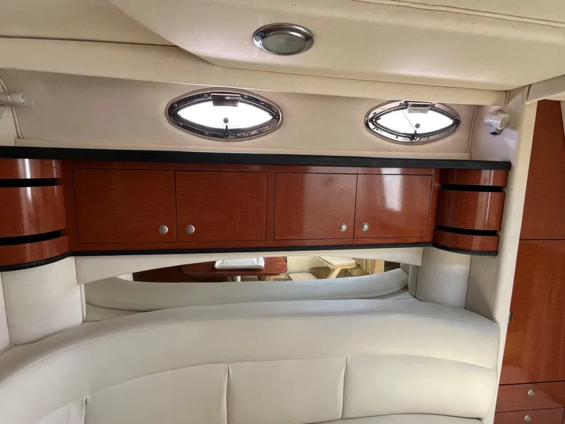 Slide: The Image of Interior of 2005 Sea Ray 300 Sundancer with wood cabinets and porthole windows. - 19