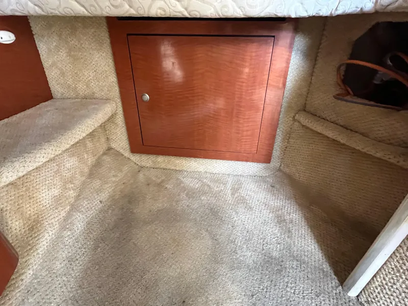 Slide: The Image of Interior cabin of 2005 Sea Ray 300 Sundancer with carpet and wooden storage. - 20