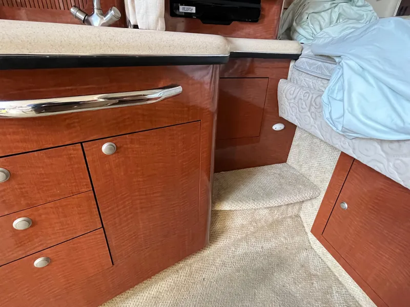 Slide: The Image of Interior of 2005 Sea Ray 300 Sundancer with wood cabinetry and cozy bedding. - 22