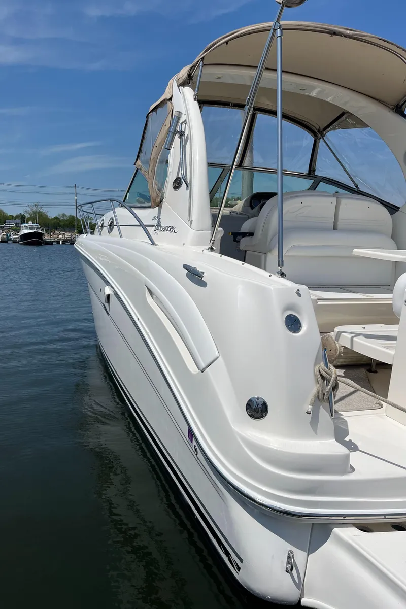 Slide: The Image of 2005 Sea Ray 300 Sundancer boat docked on calm water under clear blue sky. - 28