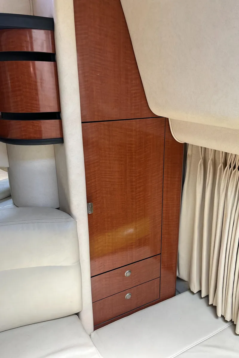 Slide: The Image of 2005 Sea Ray 300 Sundancer interior with wood cabinetry and cream upholstery. - 32
