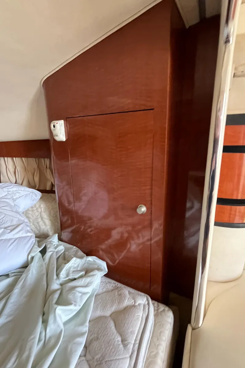 Slide: The Image of Interior cabin of 2005 Sea Ray 300 Sundancer with wooden paneling and bed. - 33