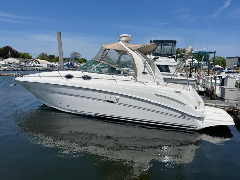 Slide: The Image of 2005 Sea Ray 300 Sundancer boat docked in a marina under clear blue skies. - 4