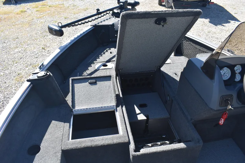 Slide: The Image of 2014 Lund 1675 Impact SS boat interior with open storage compartments and control panel. - 13