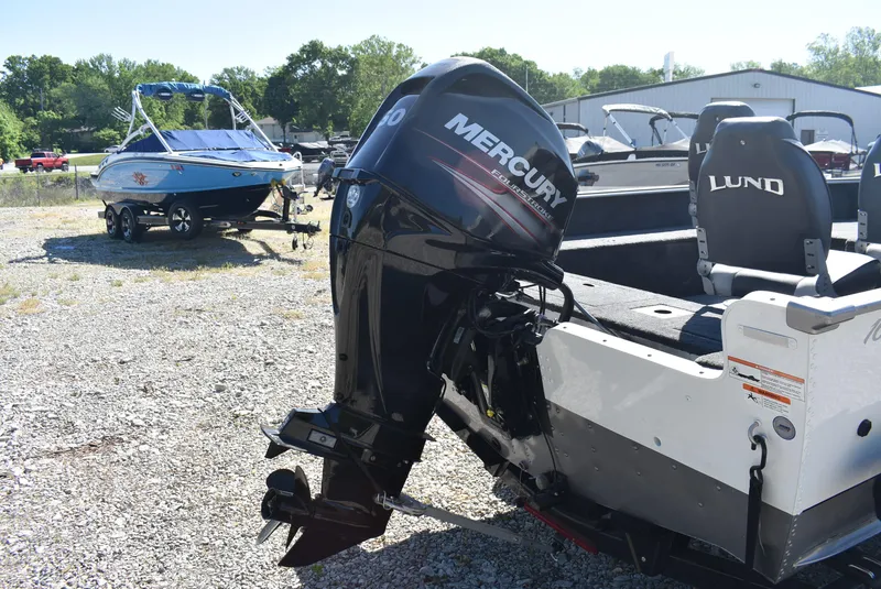 Slide: The Image of 2014 Lund 1675 Impact SS boat with Mercury outboard motor in a gravel lot. - 3