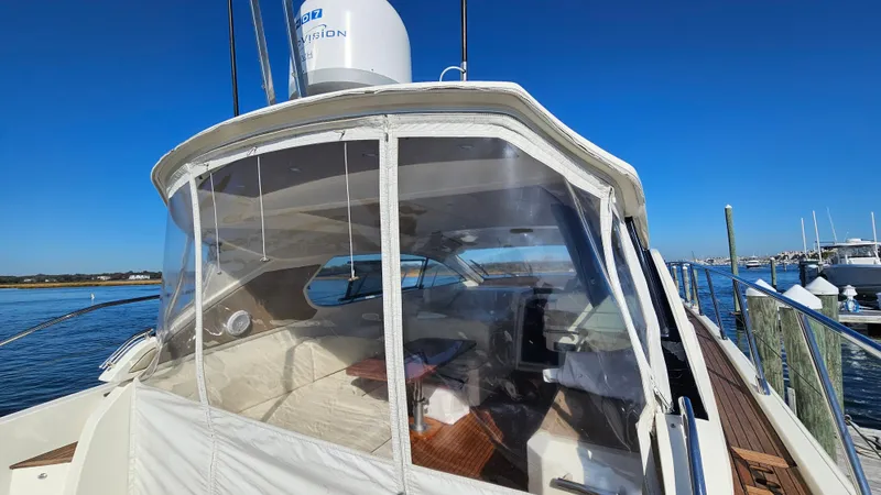 Slide: The Image of 2015 Azimut Atlantis 50 yacht with enclosed cockpit, docked by the water. - 12