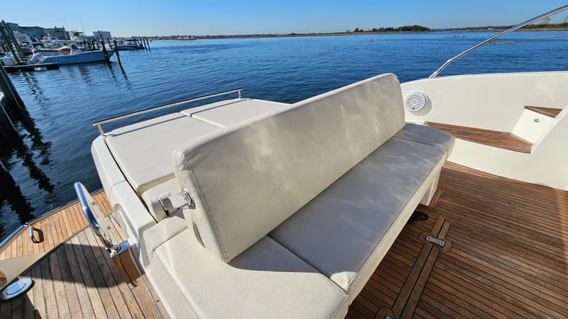 Slide: The Image of Azimut Atlantis 50 yacht deck with cushioned seating, 2015 model, overlooking serene waters. - 13
