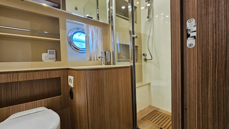 Slide: The Image of Luxurious bathroom interior of 2015 Azimut Atlantis 50 yacht with wood accents and porthole window. - 48