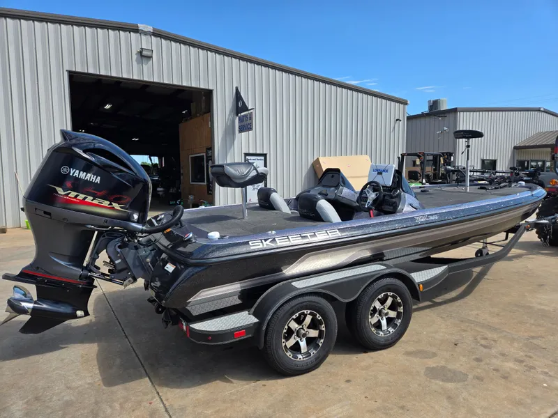 Slide: The Image of 2014 Skeeter ZX 20 bass boat with Yamaha VMAX engine, parked outside a garage. - 2