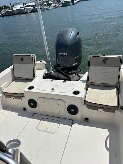 Slide: The Image of 2021 Carolina Skiff 23 LS boat with seating and outboard motor, docked by the water. - 12