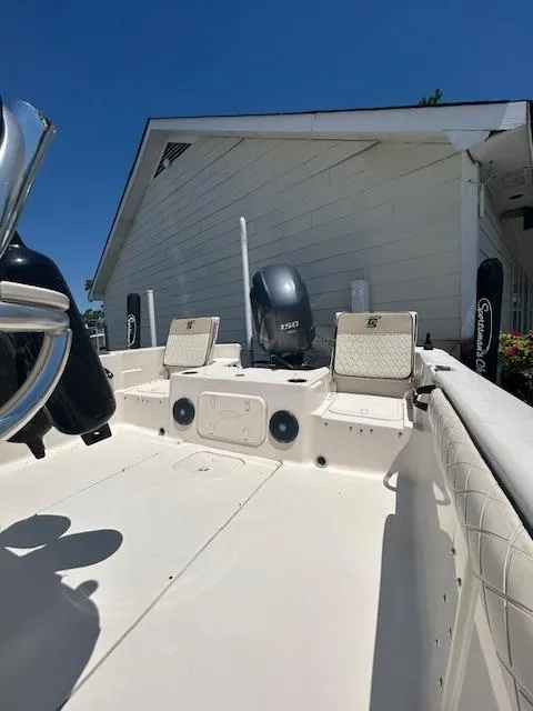 Slide: The Image of 2021 Carolina Skiff 23 LS boat with Yamaha outboard motor, docked near a white building. - 13