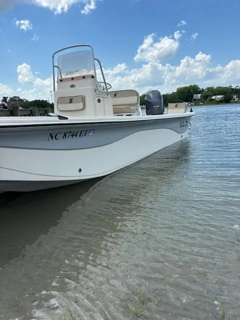 Slide: The Image of 2021 Carolina Skiff 23 LS boat on calm water under a clear blue sky. - 2