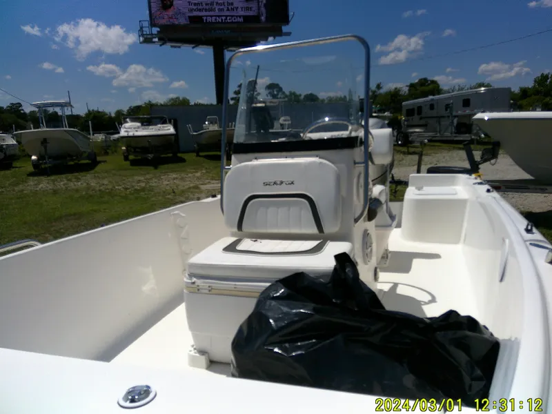 Slide: The Image of 2011 Sea Fox 172 CC boat interior with console and seating, parked outdoors. - 6