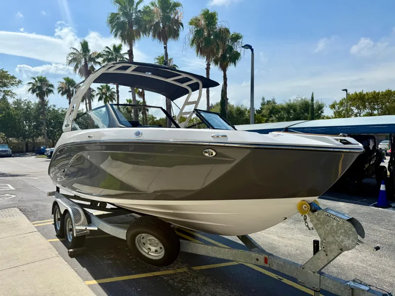 The Image of 2025 Yamaha Boats 222SD on trailer, parked under palm trees in sunny weather. - 0