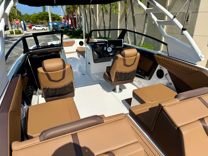 Slide: The Image of 2025 Yamaha Boats 222SD interior with brown seating and modern dashboard. - 10