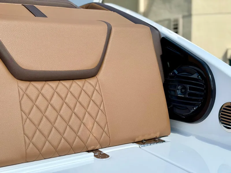 Slide: The Image of 2025 Yamaha Boats 222SD interior with tan quilted upholstery and speaker detail. - 16