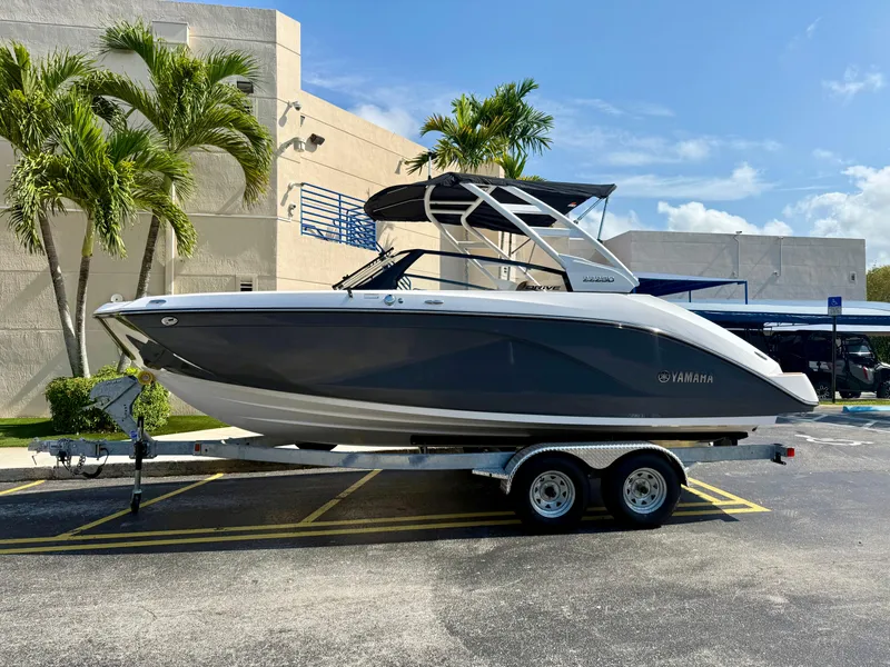 Slide: The Image of 2025 Yamaha Boats 222SD on trailer, parked outdoors near palm trees. - 5