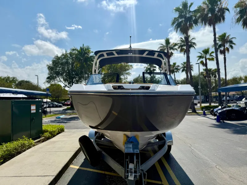 Slide: The Image of 2025 Yamaha Boats 222SD on trailer, parked under sunny skies with palm trees. - 7