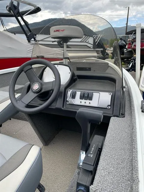 Slide: The Image of 2022 Alumacraft Escape 145 CS boat interior with steering wheel and control panel. - 1