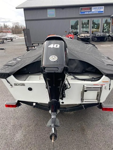 Slide: The Image of 2022 Alumacraft Escape 145 CS boat with 40 HP motor, covered and parked outdoors. - 10