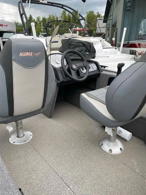 Slide: The Image of 2022 Alumacraft Escape 145 CS boat interior with steering wheel and seating. - 6
