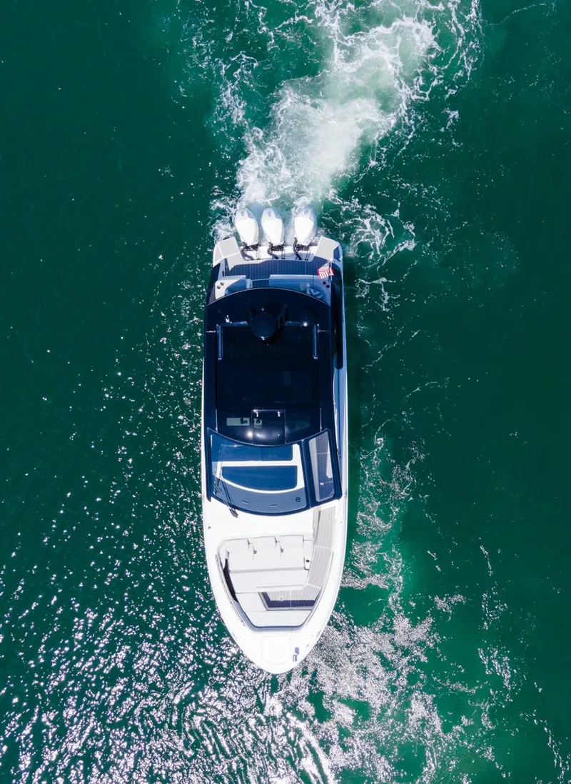 Slide: The Image of 2022 Sea Ray Sundancer 370 OB cruising on clear blue water, aerial view. - 16