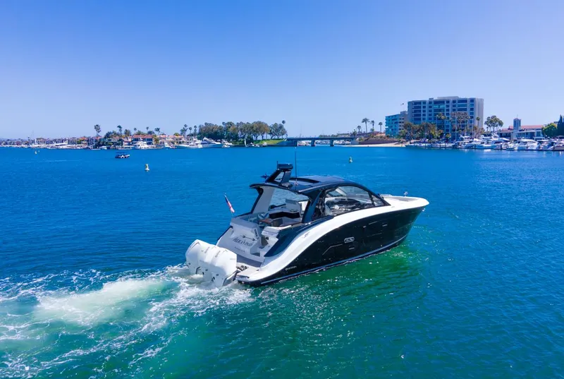Slide: The Image of 2022 Sea Ray Sundancer 370 OB cruising in a scenic marina with clear blue water. - 17