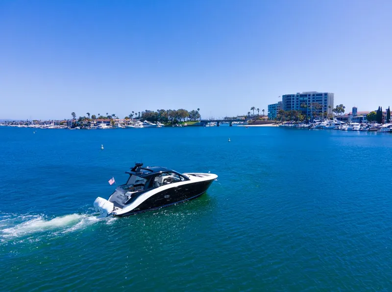 Slide: The Image of 2022 Sea Ray Sundancer 370 OB cruising in a scenic coastal harbor. - 19