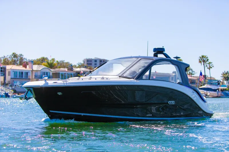 Slide: The Image of 2022 Sea Ray Sundancer 370 OB cruising on a sunny day near waterfront homes. - 2