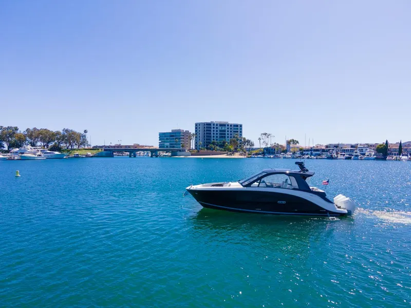 Slide: The Image of 2022 Sea Ray Sundancer 370 OB cruising on a sunny day in a coastal city. - 20