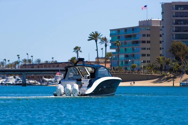 Slide: The Image of 2022 Sea Ray Sundancer 370 OB cruising near coastal buildings and palm trees. - 21