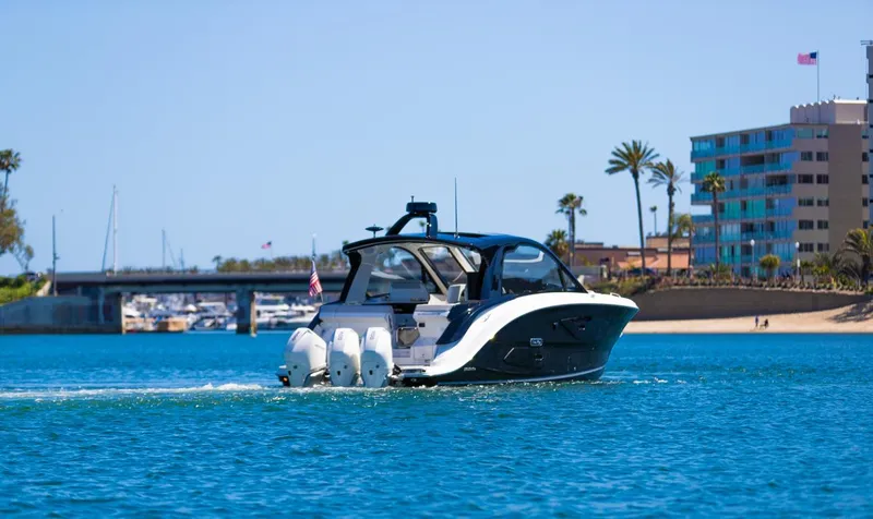 Slide: The Image of 2022 Sea Ray Sundancer 370 OB cruising in a sunny coastal setting. - 22