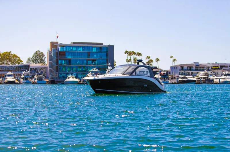 Slide: The Image of 2022 Sea Ray Sundancer 370 OB yacht on water near modern marina buildings. - 26