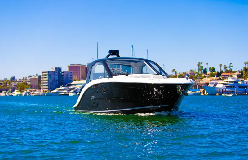 Slide: The Image of 2022 Sea Ray Sundancer 370 OB cruising on a sunny day near a marina. - 27