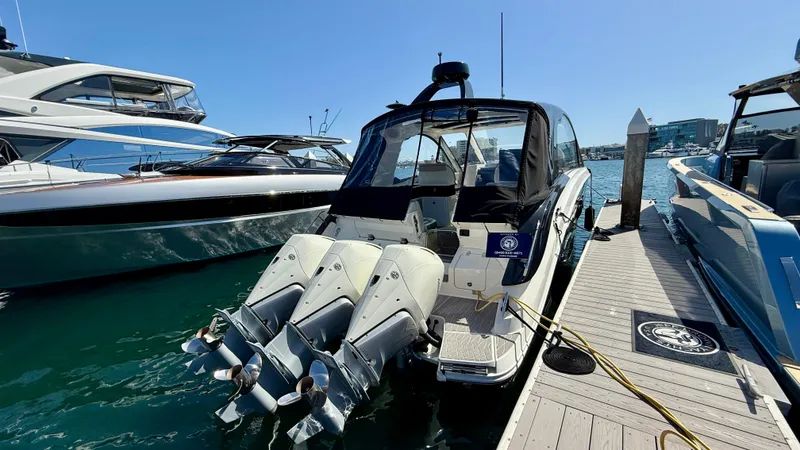 Slide: The Image of 2022 Sea Ray Sundancer 370 OB docked, featuring triple outboard engines, in a sunny marina. - 32