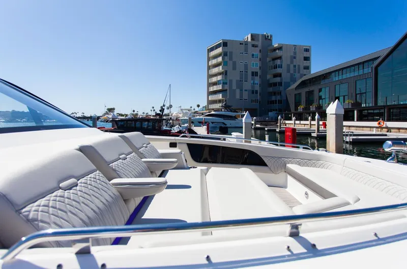 Slide: The Image of 2022 Sea Ray Sundancer 370 OB docked, showcasing luxurious seating and modern marina backdrop. - 34