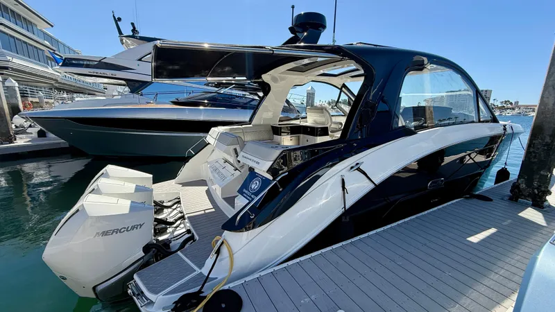 Slide: The Image of 2022 Sea Ray Sundancer 370 OB docked, showcasing sleek design and powerful Mercury outboard engines. - 48