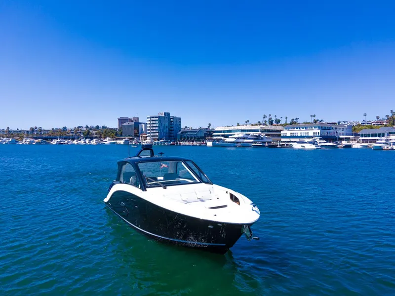 Slide: The Image of 2022 Sea Ray Sundancer 370 OB cruising in a vibrant marina under clear blue skies. - 6