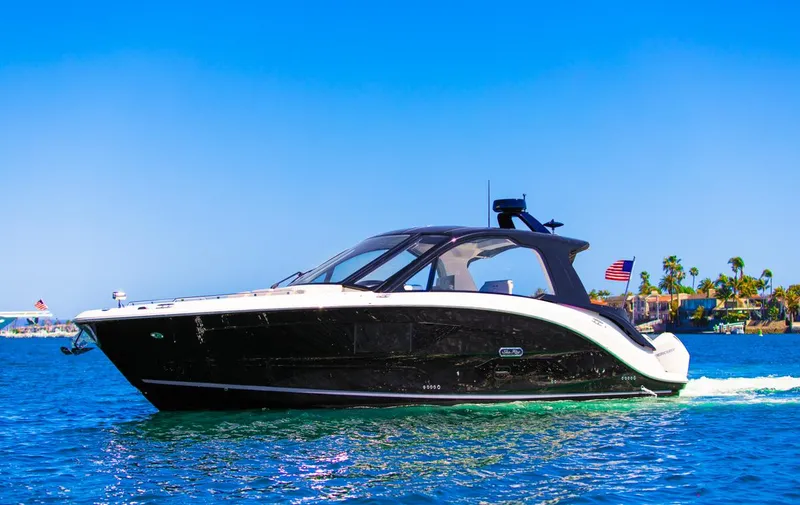 Slide: The Image of 2022 Sea Ray Sundancer 370 OB cruising on blue water under clear sky. - 8
