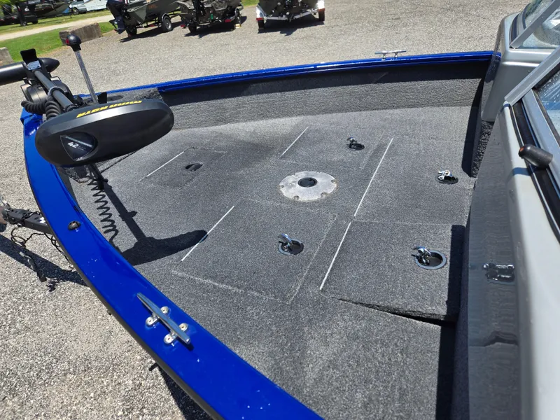 Slide: The Image of 2018 Tracker Pro Guide V-16 WT boat deck with trolling motor, blue trim, and storage compartments. - 13