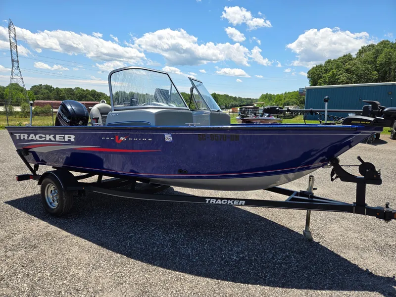 Slide: The Image of 2018 Tracker Pro Guide V-16 WT boat on trailer, parked outdoors under blue sky. - 3