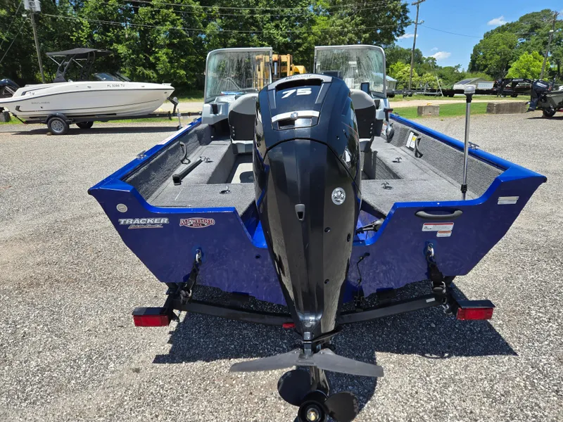 Slide: The Image of 2018 Tracker Pro Guide V-16 WT boat with 75 HP engine, parked outdoors. - 5