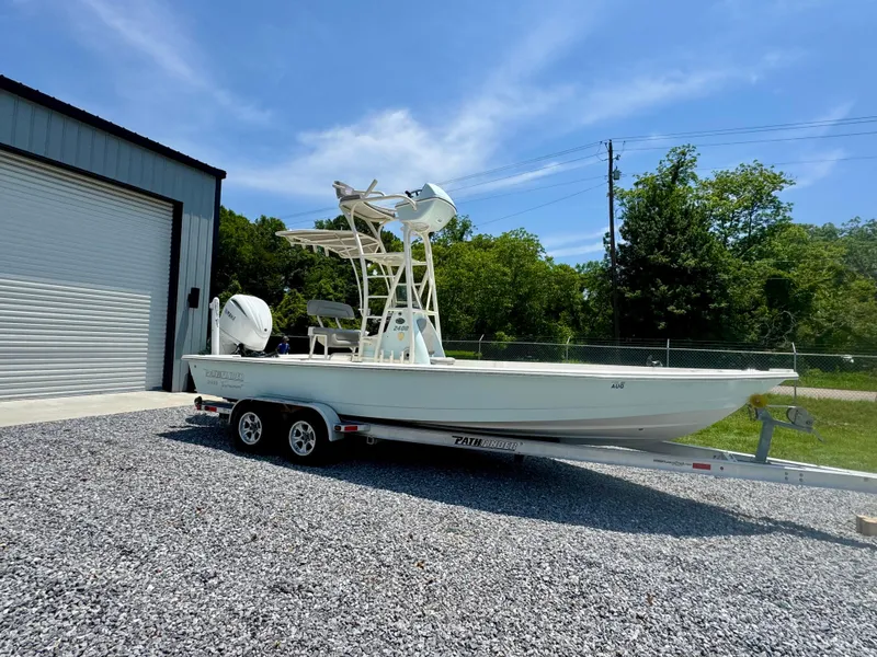Slide: The Image of 2011 Pathfinder 2400 Tournament Edition boat on trailer, parked outside a garage. - 2