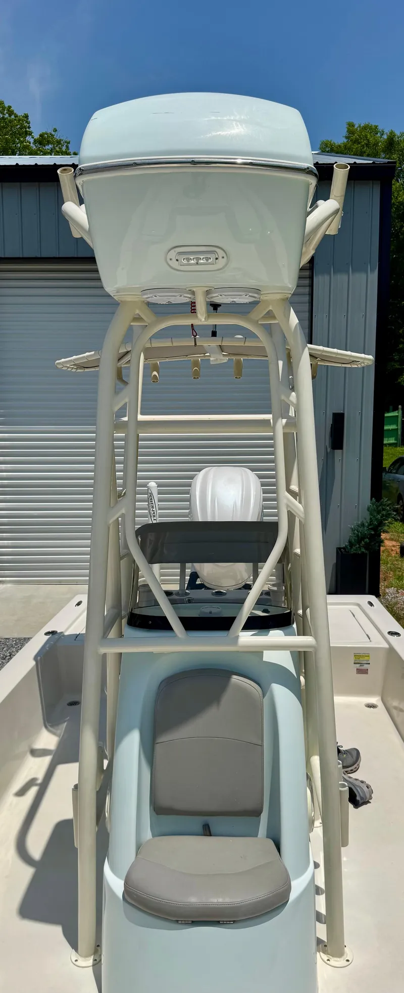 Slide: The Image of 2011 Pathfinder 2400 Tournament Edition boat with tower, docked near a metal building. - 20