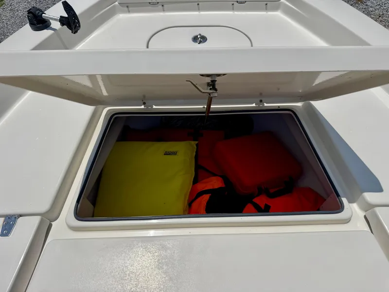 Slide: The Image of Open storage compartment on 2011 Pathfinder 2400 Tournament Edition boat with life jackets. - 22
