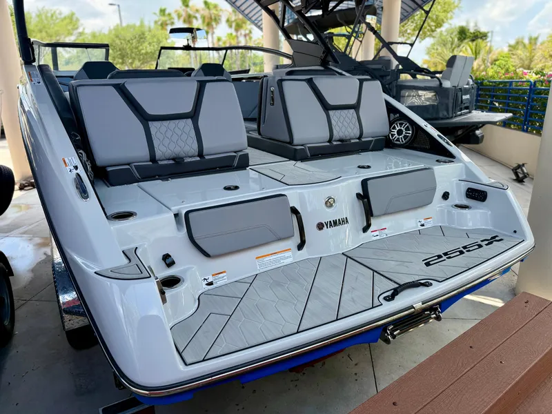 Slide: The Image of 2025 Yamaha Boats 255XD, sleek design, rear view, modern seating, outdoor display. - 5