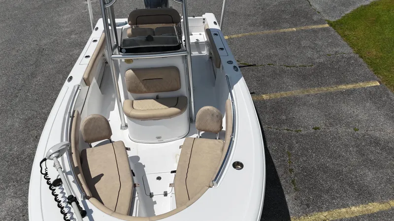 Slide: The Image of 2019 Sportsman Open 212 Center Console boat with beige seating, parked on asphalt. - 7