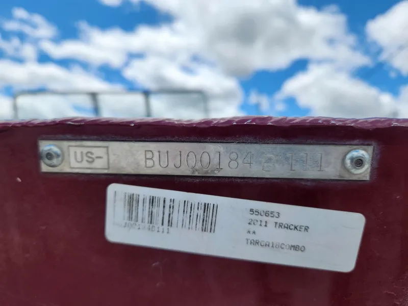 Slide: The Image of 2011 Tracker Targa V-18 Combo boat identification plate with serial number against cloudy sky. - 12