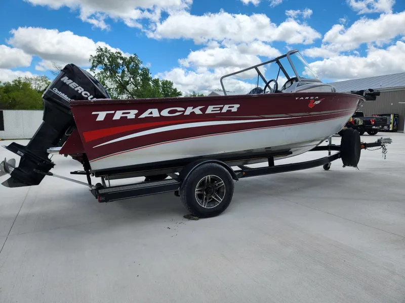 Slide: The Image of 2011 Tracker Targa V-18 Combo boat on trailer, red and white design, outdoors. - 2