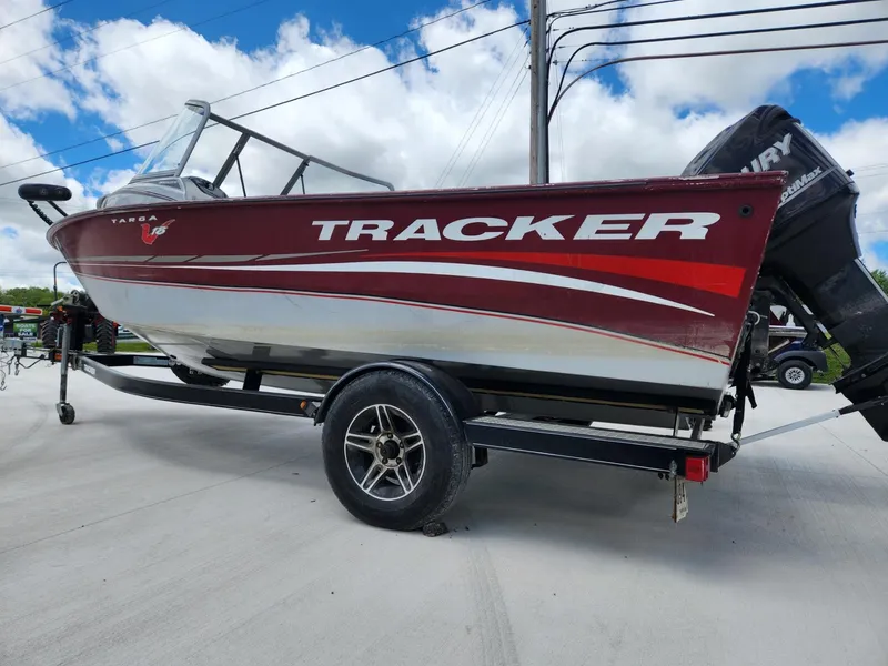 Slide: The Image of 2011 Tracker Targa V-18 Combo boat on trailer, red and white design, parked outdoors. - 3